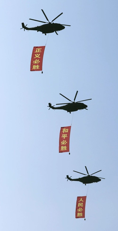 这是空中护旗梯队通过天安门广场，3架直-8L运输直升机分别悬挂“正义必胜”“和平必胜”“人民必胜”条幅。新华社记者 李钢 摄